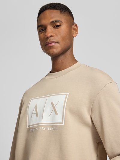 Männermodel trägt Sweatshirt mit Logo-Print und Rundhalsausschnitt von ARMANI EXCHANGE in Beige, Reine Baumwolle, Loose-Fit, Nahaufnahme Oberkörper.