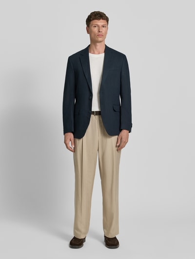 Männermodel trägt Sakko aus Viskose-Mix mit Pattentaschen von Christian Berg Men in Dunkelblau, Regular-Fit, Reverskragen, Knopfverschluss, Brustleistentasche, Rückenlänge 74 cm, Schulterbreite 46 cm, Ärmellänge 65 cm, Ganzkörperansicht von vorne.
