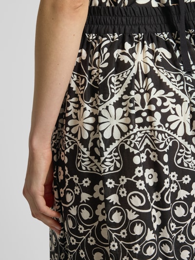 Vrouwenmodel draagt Regular Fit Hosenrock uit zuivere katoen model 'PALANCA' van Weekend Max Mara met allover patroon, high waist, elastische tailleband en zijzakken, zwarte en witte bloemenmotieven, detailopname heupzone.