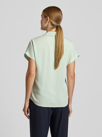 Frauenmodel trägt Relaxed Fit Hemdbluse aus reiner Viskose Modell 'LARISAANA' von Armedangels, unifarben, kurzarm, Rückansicht.