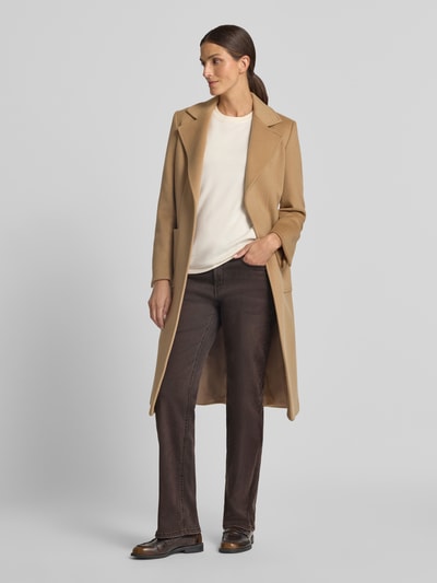 Frauenmodel trägt Straight Fit Jeans mit ausgestelltem Bein Modell 'Laura' von MAC in Braun, kombiniert mit beigem Mantel, Damen Straight Fit Jeans von MAC, Ganzkörperansicht von vorne.