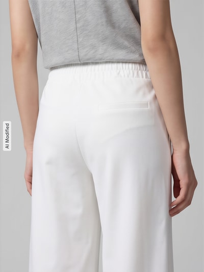 Frauenmodel trägt Stoffhose mit Eingrifftaschen von ICHI, unifarbenes Design, lockere Passform, Nahaufnahme Rückansicht, KI-modifiziertes Bild.