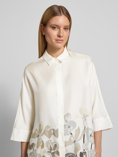 Frauenmodel trägt Relaxed Fit Hemdbluse aus reiner Seide mit floraler Print von HERZENS in Creme mit Hemdblusenkragen, 3/4-Arm, Knopfleiste, Rückenlänge 73 cm, Ärmellänge 43 cm. Nahaufnahme Oberkörper.
