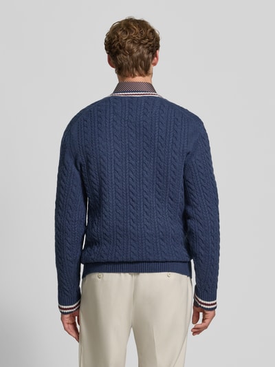 Männermodel trägt Strickpullover mit Woll-Anteil von MCNEAL in Blau mit Zopfmuster, geradem Schnitt, Ganzkörperansicht Rückansicht. Woll-Mix, gerippte Abschlüsse, Rückenlänge bei Größe M 71 cm, Ärmellänge 74 cm.
