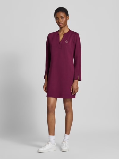 Vrouwenmodel draagt Regular fit mini-jurk uit viscosemix Model 'Abito' van Liu Jo, met siersteentjes, Serafinohals, met lange mouwen, ruglengte maat S 88 cm, borstwijdte maat S 50 cm, mouwlengte maat S 61 cm, effen bordeauxrood, gladde structuur, geheel lichaamsaanzicht van voren.