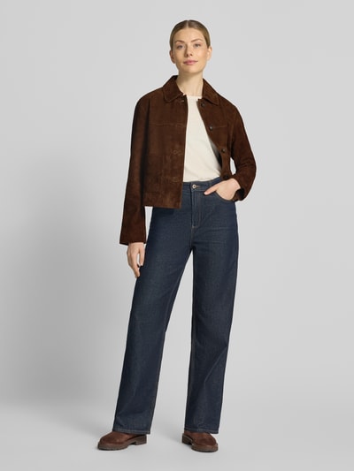 Frauenmodel trägt Lederjacke aus Ziegenvelours mit Eingrifftaschen von Christian Berg Woman, dunkelbraun, strukturierte Oberfläche, Ganzkörperansicht von vorne.