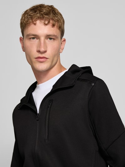 Männermodel trägt schwarze Sweatjacke mit Reißverschluss Modell 'COFUSION' von JACK & JONES, Materialmix, Nahaufnahme Oberkörper.