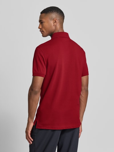 Männermodel trägt Regular Fit Poloshirt aus Baumwoll-Mix von Tommy Hilfiger, Optik: Unifarben, Applikation: Logo-Stitching, Kurzarm, Piqué, Ganzkörperansicht Rückansicht