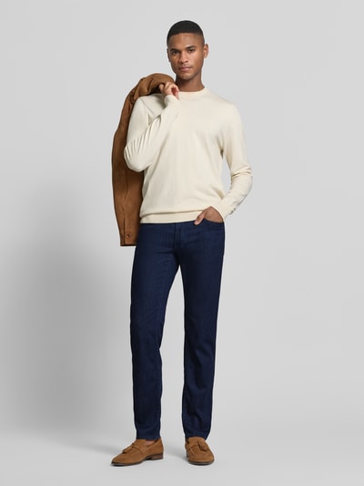 Männermodel trägt Slim Fit Jeans mit Seiden-Anteil Modell 'Chuck' von BRAX im 5-Pocket-Design, dunkelblauer Elastischer-Material-Mix, Ganzkörperansicht von vorne.
