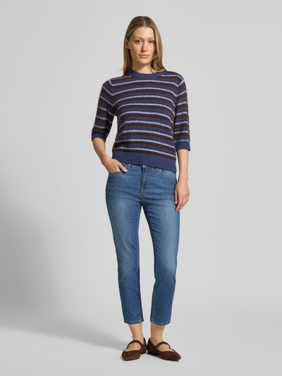 Modelka nosi Jeans in verkürzter Passform Modell 'Mary' od Brax, bawełniany materiał ze stretchem, jasny niebieski kolor, fason slim fit, przednie kieszenie, szerokość w rozmiarze 36: 37 cm, długość wewnętrzna nogawki w rozmiarze 36: 69 cm, całkowity widok z przodu.