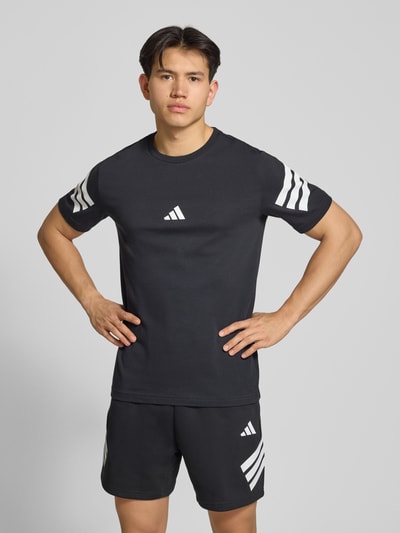 Männermodel trägt Regular Fit T-Shirt aus reiner Baumwolle von adidas Sportswear, unifarben, Logo-Print, Kurzarm, Ganzkörperansicht von vorne.