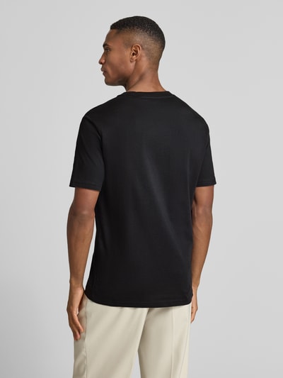 Männermodel trägt T-Shirt mit Label-Print von MARC O'POLO in Schwarz, gerader Schnitt, reine Baumwolle, Rückansicht, Ganzkörperansicht