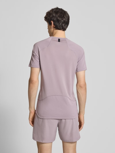 Männermodel trägt T-Shirt mit Logo-Print und Raglanärmeln von NIKE TRAINING in Flieder, Straight Fit, Rückenlänge 71 cm, Ganzkörperansicht Rückansicht.