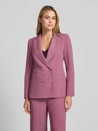 Vrouwenmodel draagt blazer met dubbele knoopsluiting van Rinascimento in zachtroze, reverskraag, getailleerd, paspelzakken, ruglengte maat S 64 cm, close-up bovenlichaam vooraanzicht