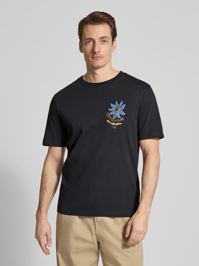 Männermodel trägt T-Shirt mit Label-Prints und Rundhalsausschnitt von Scotch & Soda aus reiner Baumwolle, Regular-Fit, Ganzkörperansicht von vorne.
