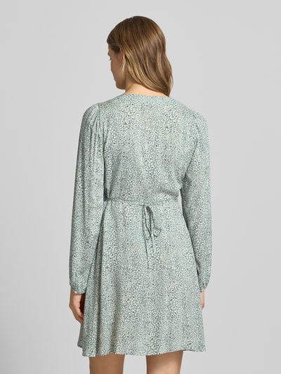 Frauenmodel trägt Tailliertes Freizeitkleid aus reiner Viskose Modell 'EVIDA' von Only mit Allover-Muster in Mint, Mini-Länge, Ballonärmel, Knopfleiste, Ganzkörperansicht Rückansicht.