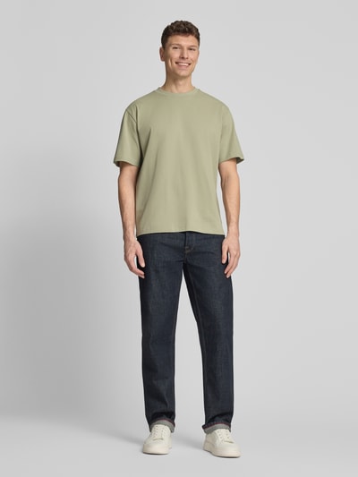 Mężczyznamodel nosi Oversized T-Shirt mit Rundhalsausschnitt von Lindbergh, męski t-shirt, bawełna, krój oversized, okrągły dekolt, detal z logo, długość tyłu w rozmiarze M: 70 cm, Ganzkörperansicht von vorne.
