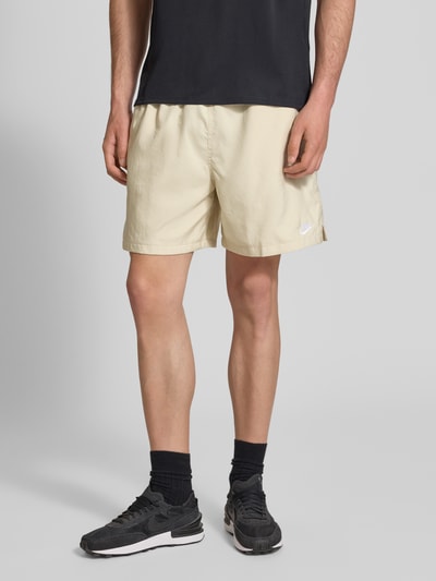 Männermodel trägt Shorts mit Label-Stitching und elastischem Bund von Nike in Beige, Regular-Fit, Tunnelzug, Nahaufnahme Oberschenkel.