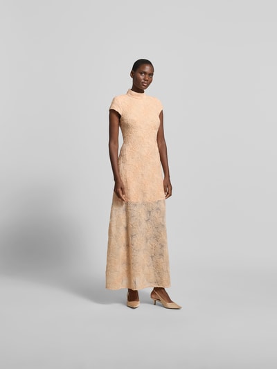 Frauenmodel trägt Maxikleid mit floralen Allover-Details von ROTATE, Elastischer-Material-Mix, taillierte Passform, Stehkragen, Kurzärmelig, sanfte Pfirsich- und Cremetöne, matte Textur, Musterung, Gesamtlänge 142 cm, Brustweite 38 cm, Ganzkörperansicht von vorne.