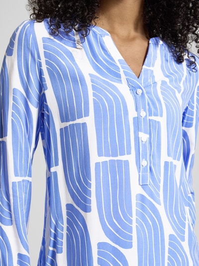 Frauenmodel trägt Wellen-Print Schlupfbluse aus Viskose von Christian Berg Woman, blau-weiß gemustert, Regular Fit, Nahaufnahme Oberkörper.