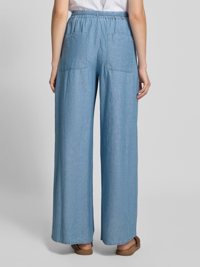 Vrouwenmodel draagt Wide Fit broek met bandplooien in denimlook van Stefanel, puur katoen, elastische band, bandplooien, binnenbeenlengte maat S 79 cm, bandwijdte maat S 36 cm, kleur lichtblauw, rechte wijde pijpen, textuur zacht, geheel lichaamsaanzicht achteraan.