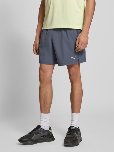 Männermodel trägt Shorts mit elastischem Bund und Logo von PUMA PERFORMANCE in Blau, Material-Mix mit Stretch-Anteil, Regular-Fit, Nahaufnahme Oberschenkel.