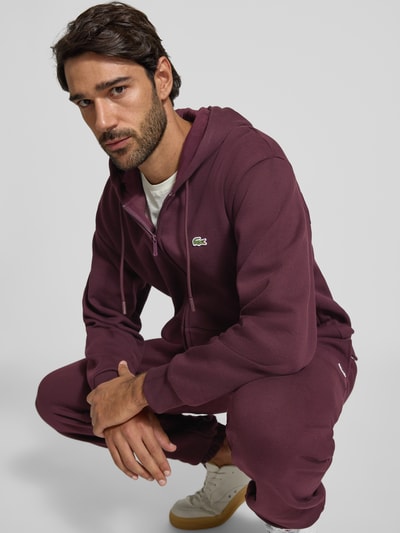 Mannenmodel draagt Classic Fit sweatjack van katoenmix van Lacoste in bordeauxrood, Heren sweatjack, Ganzkörperansicht von vorne.