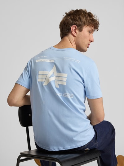 Männermodel trägt T-Shirt mit Label-Patch von Alpha Industries, hellblau, reine bawełna, prosty krój, okrągły dekolt, długość tyłu 66 cm w rozmiarze M, Ganzkörperansicht Rückansicht