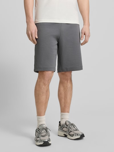 Männermodel trägt Shorts mit elastischem Bund von EA7 Emporio Armani in Grau, Baumwoll-Mix, Regular Fit, Ganzkörperansicht von vorne.