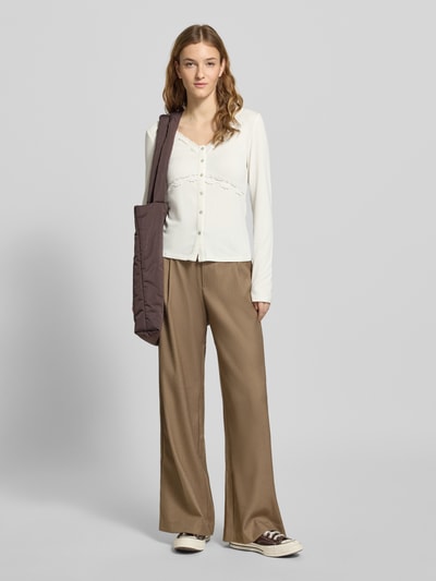 Frauenmodel trägt Slim Fit Langarmshirt aus Viskose-Mix Modell 'SINI' von Only, unifarben mit Knopfleiste, V-Ausschnitt, Spitze, Ganzkörperansicht von vorne.
