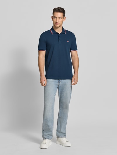 Männermodel trägt Regular Fit Poloshirt mit Kontraststreifen von Christian Berg Men aus reiner Baumwolle, Knopfleiste, Ganzkörperansicht von vorne.