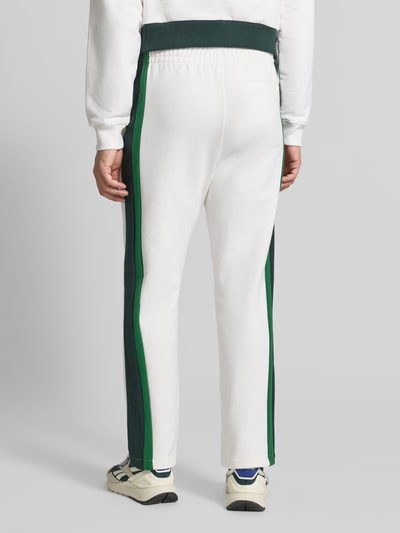 Männermodel trägt Relaxed Fit Sweathose aus reiner katoen model 'XH9800-00' von Lacoste, wit met groene strepen, Heren Sweathose, Ganzkörperansicht Rückansicht.