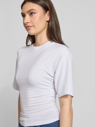 Frauenmodel trägt T-Shirt in tailliertem Schnitt Modell 'ELORA' von JJXX aus Baumwoll-Mix mit Modal, weiß, Nahaufnahme Oberkörper.