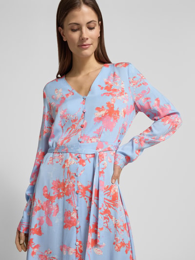Frauenmodel trägt Maxikleid mit Bindegürtel Modell 'Sicca' von mbyM aus reiner Viskose, Allover-Blumenmuster in Hellblau und Korallrot, Knopfleiste, gerader Schnitt, V-Ausschnitt, Nahaufnahme Oberkörper.