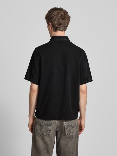Męski model nosi Relaxed Fit Jeanshemd aus Lyocell-Baumwoll-Mix von Marc O'Polo Denim, czarny denim, krótki rękaw, widok całej sylwetki z tyłu.