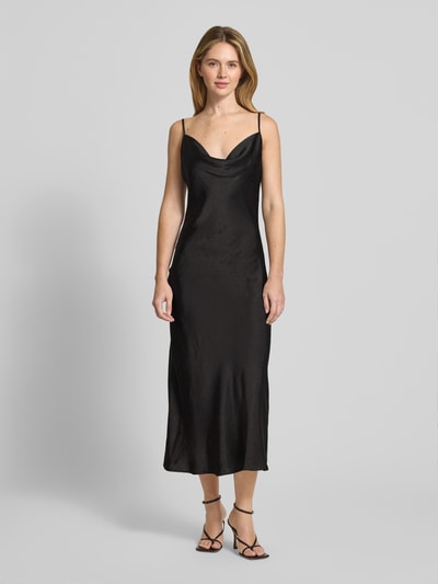 Frauenmodel trägt Midikleid mit Ziersteinbesatz Modell 'NEW AKILINA' von Guess aus schwarzem Satin mit Crinkle-Optik, körpernaher Passform, verstellbaren Spaghettiträgern, Wasserfall-Ausschnitt und Midilänge, Ganzkörperansicht von vorne.