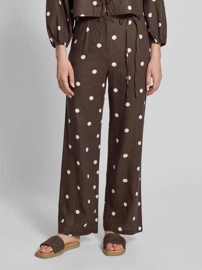 Frauenmodel trägt Stoffhose mit Schleifen-Detail von Jake*s Casual in Dunkelbraun mit weißen Punkten, Lockerer-Schnitt, Nahaufnahme Unterkörper. Bundweite bei Größe 36: 40 cm, Innenbeinlänge bei Größe 36: 83 cm.