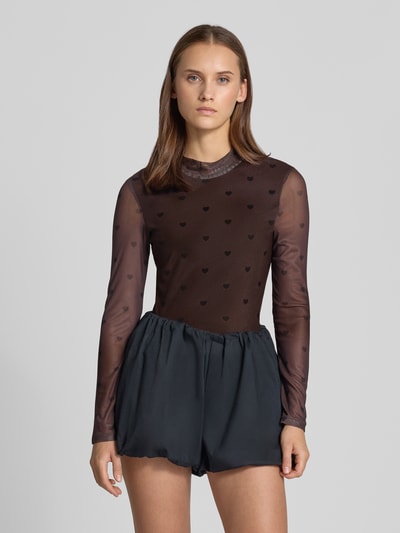 Kobieta modelka nosi Slim Fit Langarmshirt mit Allover-Muster Modell 'ERICA' od ONLY, siatkowy materiał, wzór serca, wysoki dekolt, czarny i brązowy, krój slim fit, całkowity widok z przodu.