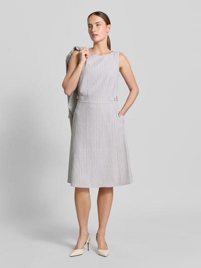 Vrouwenmodel draagt Knielanges Kleid aus Seersucker met Streifen und Lurex van Christian Berg Woman Selection, grijze gelinieerde A-lijn, ronde hals, knielengte, seersucker met streepmotief en lurex, ruglengte maat 36: 100 cm, borstwijdte maat 36: 45 cm, geheelbeeld van voren.