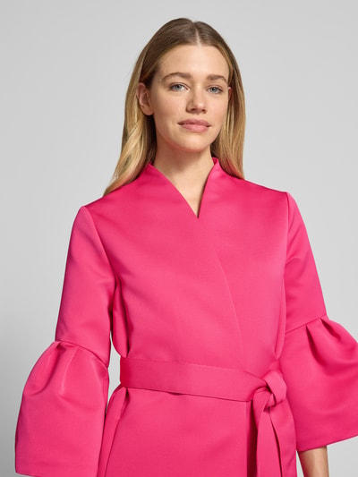 Frauenmodel trägt Blazer mit ausgestellten Ärmelabschlüssen von Marc Cain in Pink, Stehkragen, Stoffband, Nahaufnahme Oberkörper.