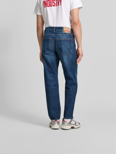 Männermodel trägt Straight Fit Jeans aus reiner Baumwolle von Diesel in Blau mit 5-Pocket-Design und Label-Patch, Ganzkörperansicht Rückansicht.