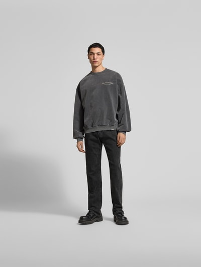 Männermodel trägt Bootcut Fit Jeans aus Baumwoll-Mix von Don't Waste Culture in Schwarz mit Kontrastnähten und 5-Pocket-Design, Ganzkörperansicht von vorne.