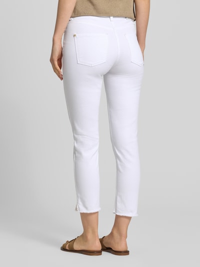 Frauenmodel trägt Slim Fit Jeans mit Fransensaum Modell 'PIPER SHORT' von Cambio, weiß, Baumwoll-Mix mit Stretch-Anteil, Eingrifftaschen, Gesäßtaschen, Knopf- und Reißverschluss, Körpernaher-Schnitt, Bundweite 39 cm, Innenbeinlänge 68 cm, Ganzkörperansicht Rückansicht.