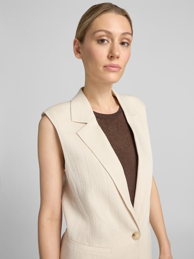 Vrouwenmodel draagt bodywarmer uit Viscosemix met Reverskraag van comma, relaxed fit, knoopsluiting, Steekzakken, Nahaufnahme Oberkörper.