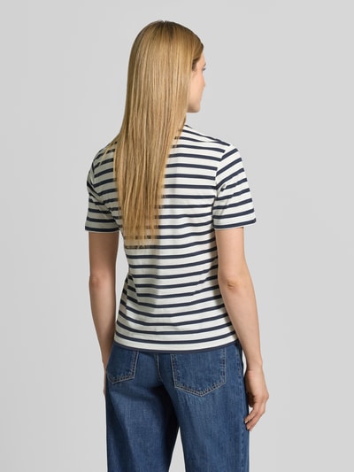 Modelka kobieca ma na sobie damski t-shirt z okrągłym dekoltem od Jake*s Casual, bawełna, prosty krój, rękaw o dł. 1/2, długość tyłu w rozmiarze S: 61 cm, białe i granatowe paski, widok całej sylwetki z tyłu.