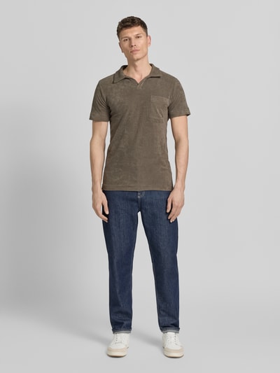Mannenmodel draagt Relaxed Fit Poloshirt met V-hals van Lindbergh in bruin katoenmix badstof met borstzak, ruglengte maat M 76 cm, geheellichaamsaanzicht van voren.
