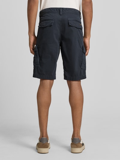 Männermodel trägt Bermudas mit Pattentaschen und Label-Stitchings von PME Legend in Dunkelblau, Straight Fit, Ganzkörperansicht Rückansicht. Bundweite 41 cm, Innenbeinlänge 26 cm, mit Seitliche Eingrifftaschen, Gesäßtaschen, Knopf- und Reißverschluss, Motiv- und Label-Stitchings, Klettverschluss.