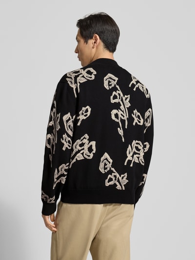 Męski model nosi Cardigan im Allover-Look Modell 'Leif' od Wood Wood, czarna dzianina z beżowym wzorem, krój regular fit, widok całej sylwetki od tyłu.