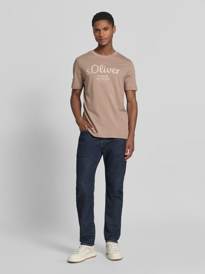 Męski model nosi Regular Fit T-Shirt aus reiner Baumwolle von s.Oliver RED LABEL, jednokolorowy, nadruk z logo, okrągły dekolt, krótki rękaw, dżersej, bawełna, ganzkörperansicht von vorne.