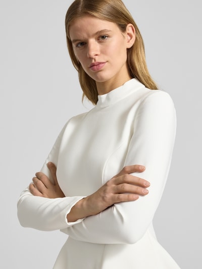 Frauenmodel trägt Cocktailkleid mit Stehkragen Modell 'ZEPHYRA' von Bardot im weißen Material-Mix mit Viskose-Anteil, Nahaufnahme Oberkörper.